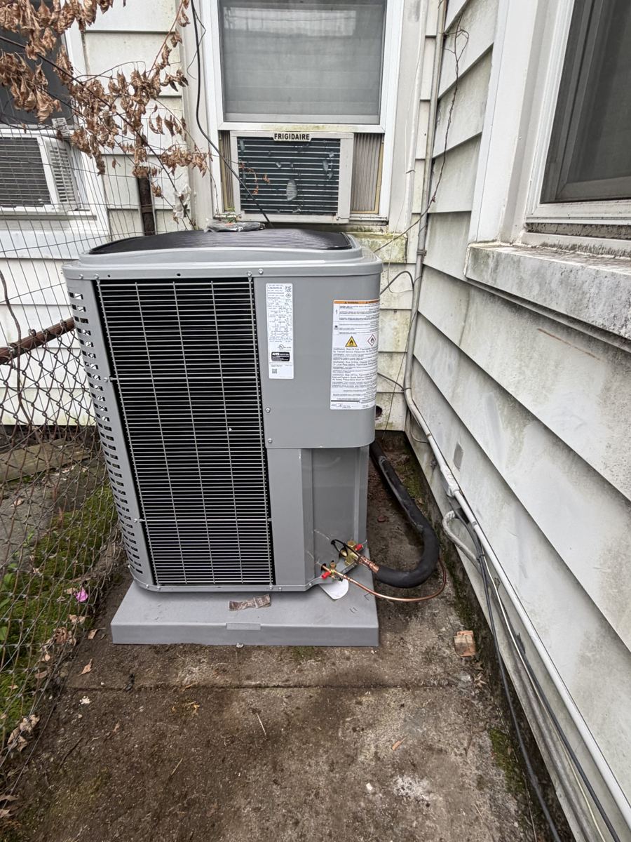 Residential outdoor AC condenser beside a home